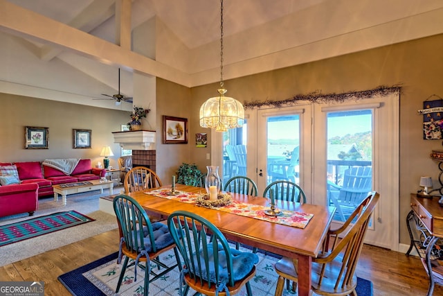 dining room with hardwood / wood-style floors, vaulted ceiling with beams, and ceiling fan with notable chandelier