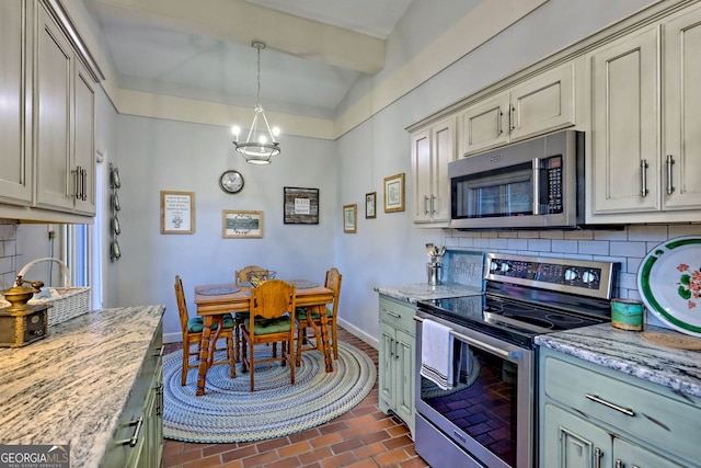 kitchen featuring light stone countertops, appliances with stainless steel finishes, pendant lighting, and backsplash