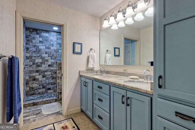 bathroom with vanity, a shower, and a textured ceiling