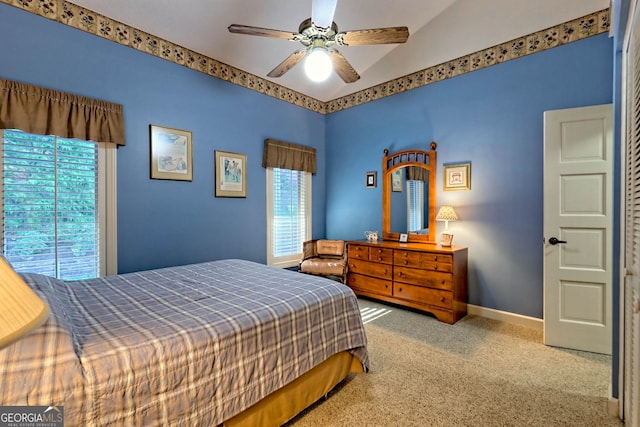 bedroom with ceiling fan, vaulted ceiling, and carpet floors