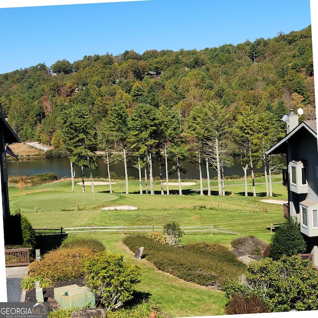 view of property's community featuring a lawn and a water view