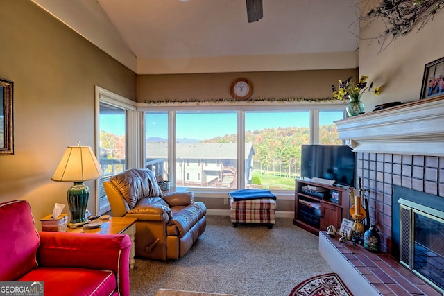 carpeted living room featuring vaulted ceiling and a tile fireplace