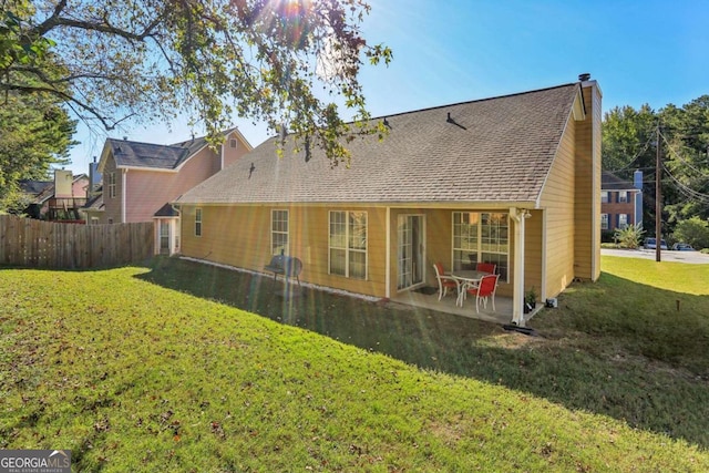 back of house with a patio area and a lawn