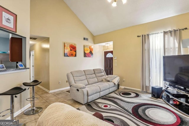 living room with high vaulted ceiling and light tile patterned floors