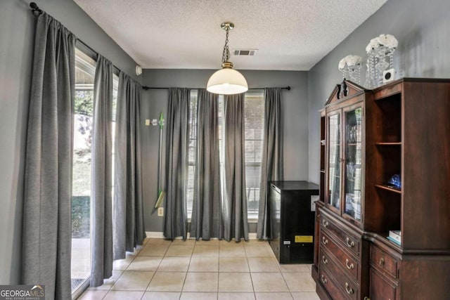 dining space featuring a textured ceiling and light tile patterned floors