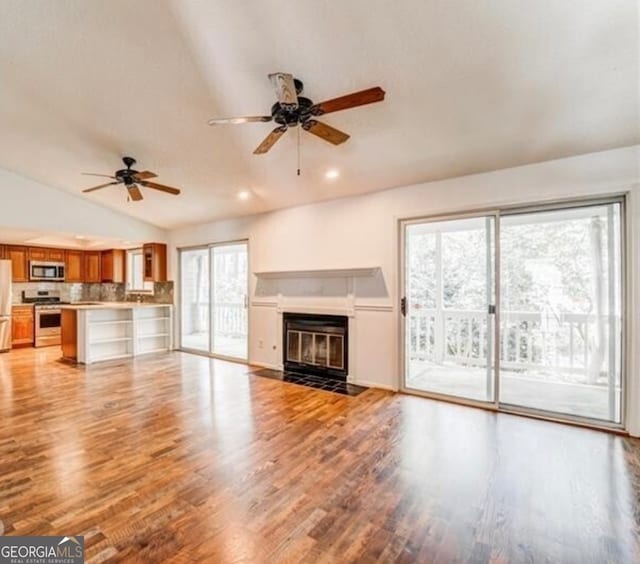 unfurnished living room featuring ceiling fan, lofted ceiling, and light wood-type flooring