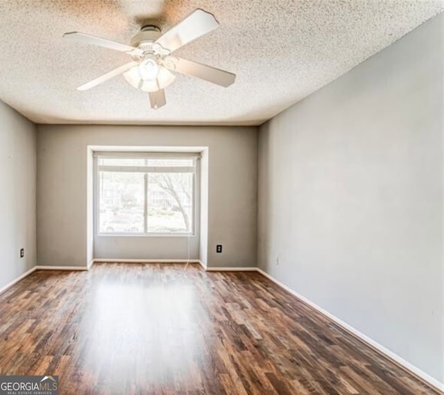 empty room with dark wood-type flooring, ceiling fan, and a textured ceiling