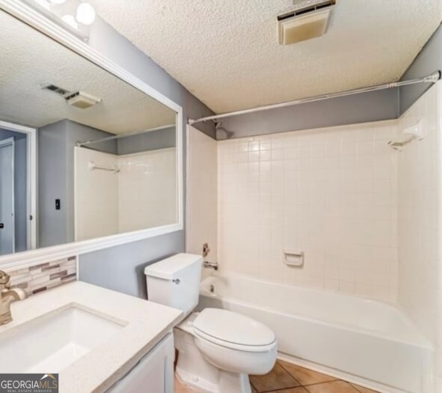 full bathroom featuring toilet, tiled shower / bath combo, vanity, and a textured ceiling