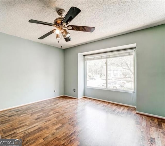 spare room with hardwood / wood-style floors, a textured ceiling, and ceiling fan