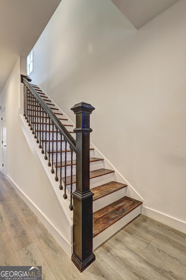 stairs with wood finished floors and baseboards