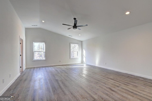 unfurnished room featuring lofted ceiling, light wood-style flooring, visible vents, baseboards, and a ceiling fan