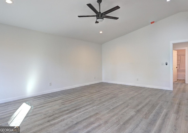 empty room with light wood-type flooring, vaulted ceiling, baseboards, and ceiling fan