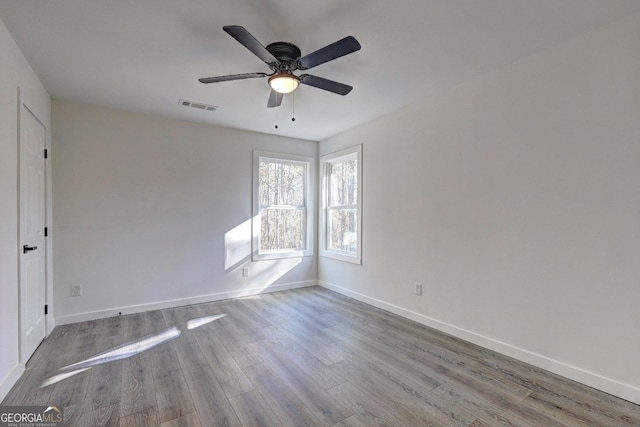 unfurnished room with light wood-type flooring, baseboards, visible vents, and ceiling fan