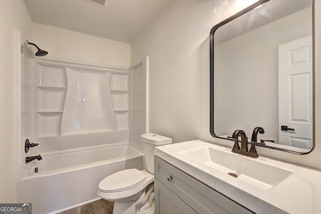 full bath with toilet, wood finished floors, visible vents, vanity, and washtub / shower combination