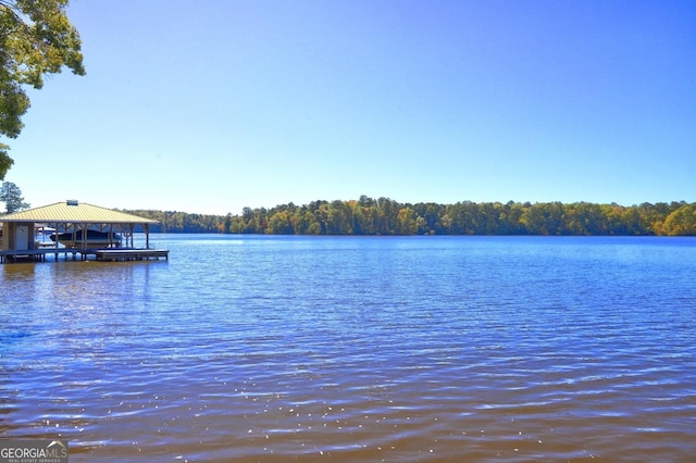 view of water feature featuring a dock and a wooded view