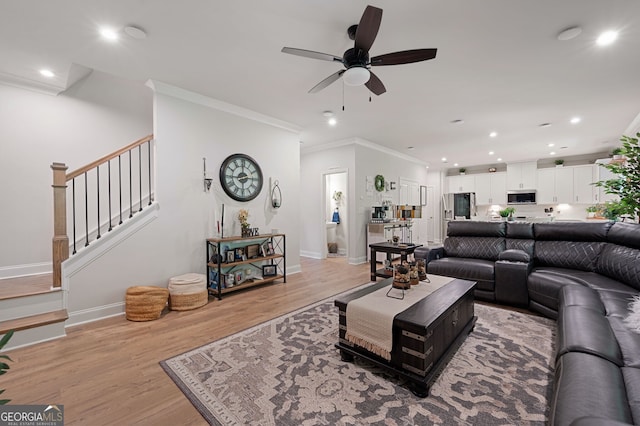 living room with ceiling fan, light hardwood / wood-style floors, and ornamental molding