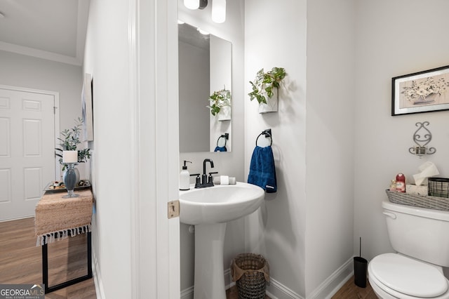 bathroom featuring crown molding, sink, wood-type flooring, and toilet