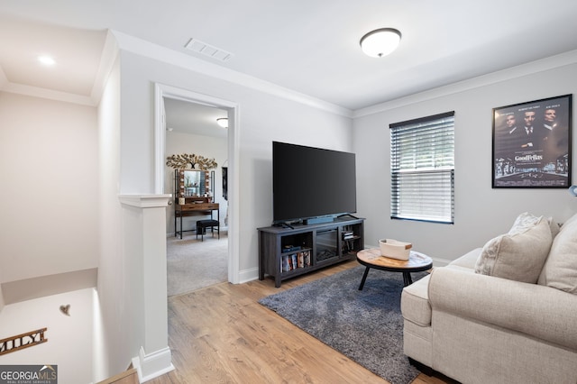 living room with light wood-type flooring and ornamental molding