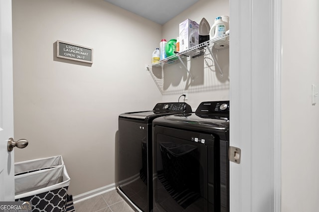 laundry room with washer and clothes dryer and light tile patterned floors