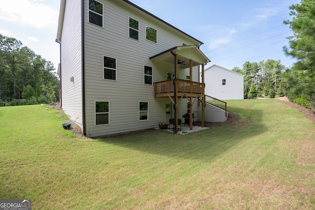 rear view of property with ceiling fan and a yard