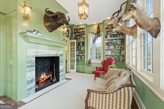 sitting room featuring a fireplace, built in features, and ornamental molding