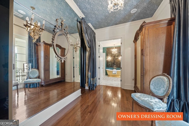 interior space with hardwood / wood-style floors, a notable chandelier, and ornamental molding