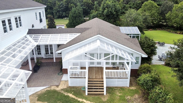 back of house with a lawn and covered porch