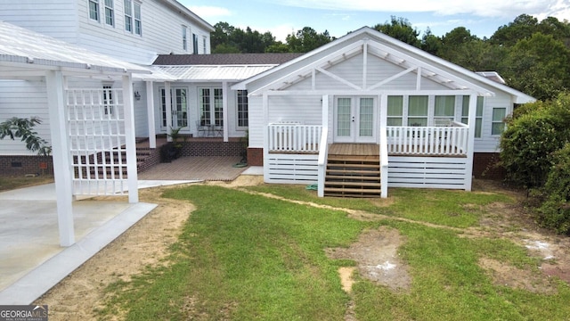 back of house featuring a yard, french doors, and covered porch