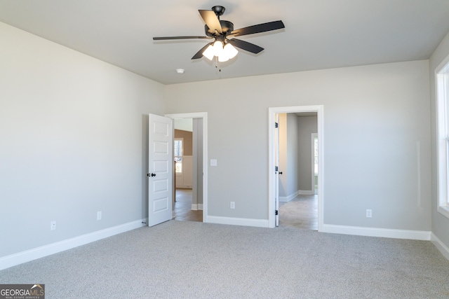 unfurnished bedroom featuring multiple windows, ceiling fan, and light colored carpet