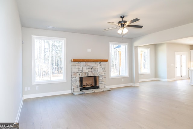 unfurnished living room featuring ceiling fan, a fireplace, and light hardwood / wood-style flooring