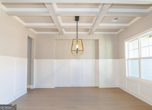 empty room featuring beamed ceiling, light wood-type flooring, and coffered ceiling