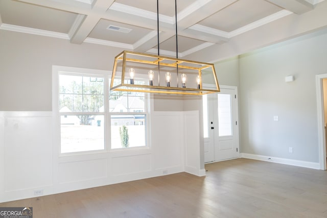 unfurnished dining area with beam ceiling, coffered ceiling, and hardwood / wood-style floors