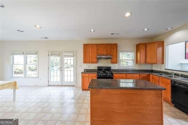 kitchen with sink, black appliances, a wealth of natural light, and a kitchen island