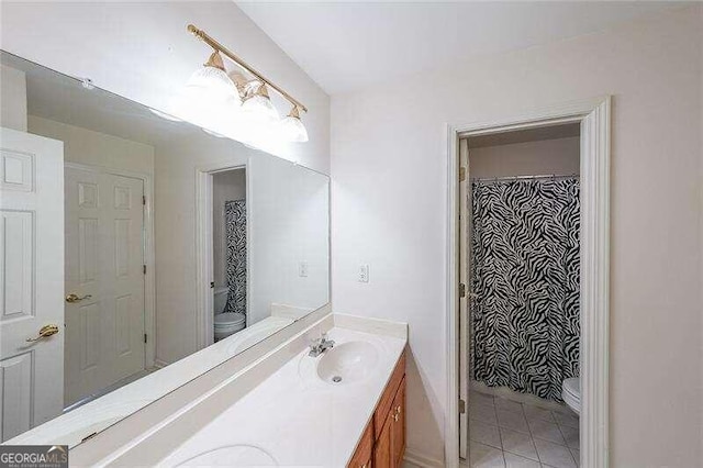 bathroom featuring toilet, vanity, and tile patterned flooring