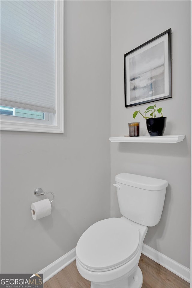 bathroom with toilet and wood-type flooring