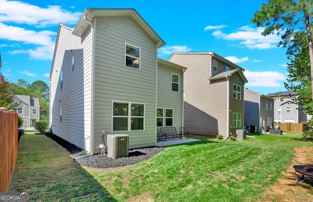 rear view of house featuring a patio, central AC unit, and a lawn