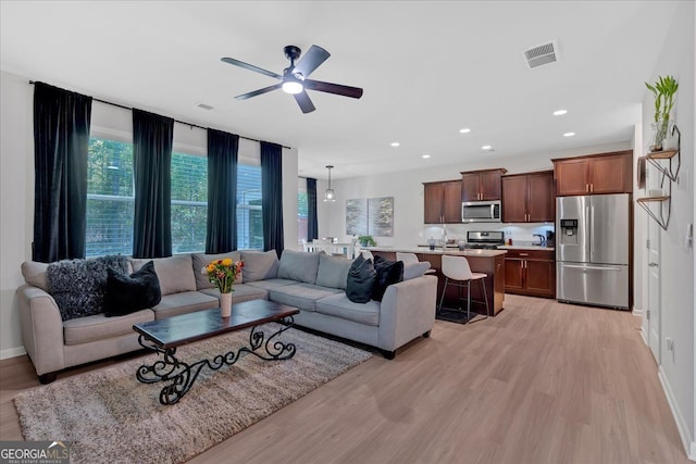 living room featuring light hardwood / wood-style floors and ceiling fan