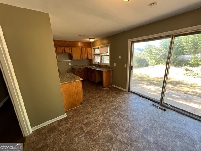 kitchen featuring stone countertops and sink