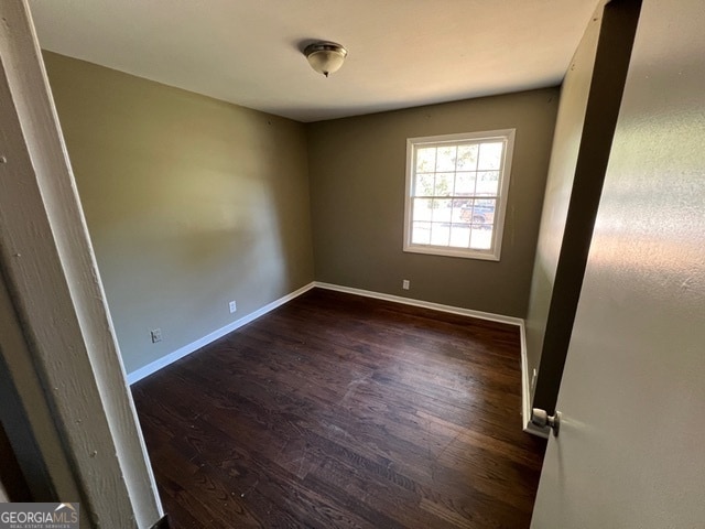 spare room featuring dark hardwood / wood-style flooring