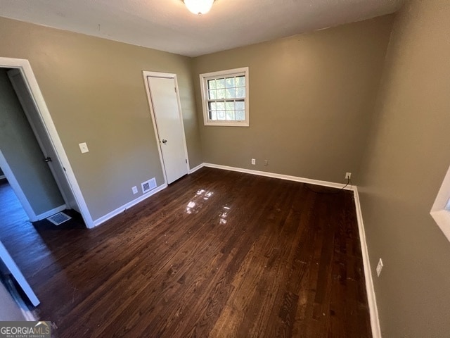 unfurnished bedroom with dark hardwood / wood-style flooring