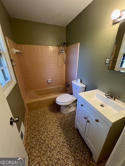 full bathroom with toilet, tiled shower / bath, and vanity