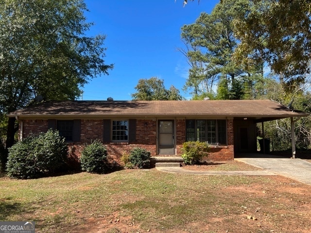 single story home featuring a carport and a front lawn