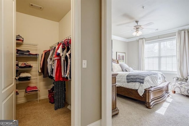 carpeted bedroom with ceiling fan and ornamental molding