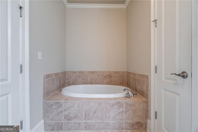 bathroom with tiled bath and ornamental molding