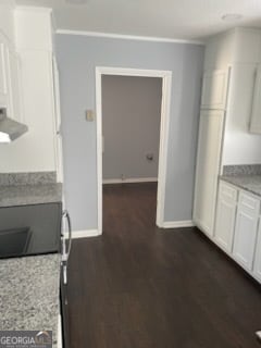 kitchen with exhaust hood, white cabinetry, light stone countertops, dark hardwood / wood-style floors, and crown molding