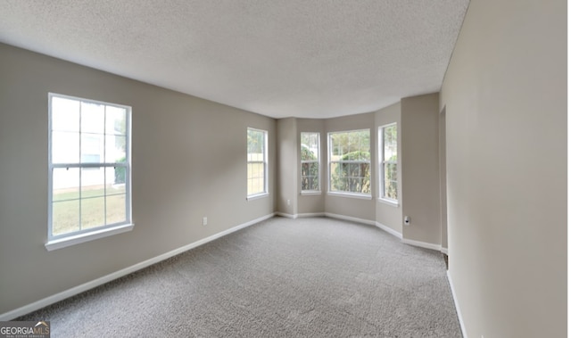 carpeted spare room with a textured ceiling