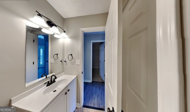 bathroom with vanity, a textured ceiling, and hardwood / wood-style floors