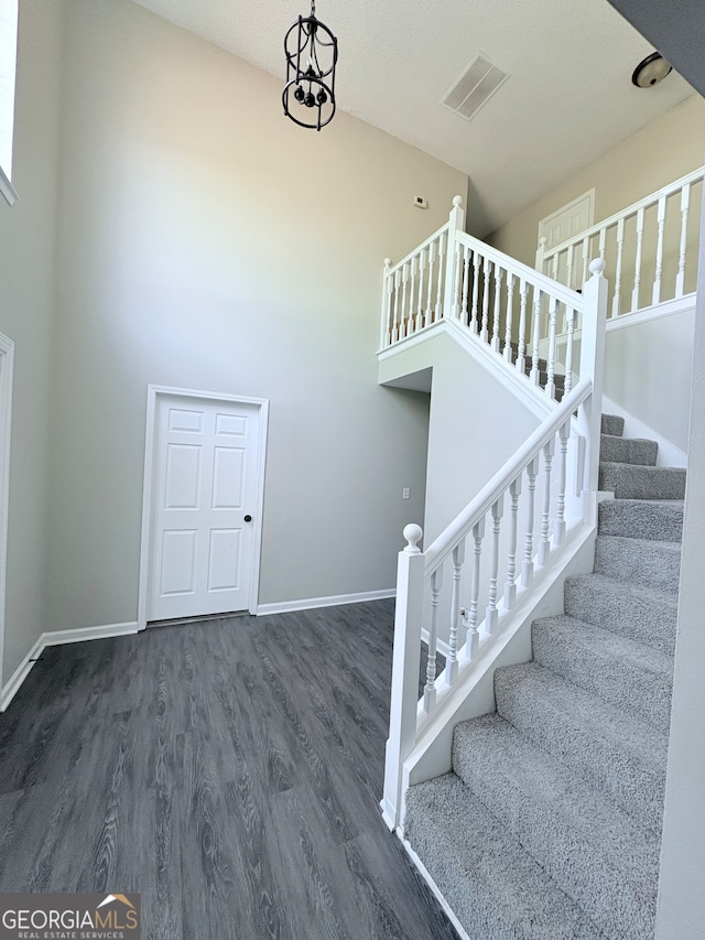 staircase featuring hardwood / wood-style floors and a textured ceiling