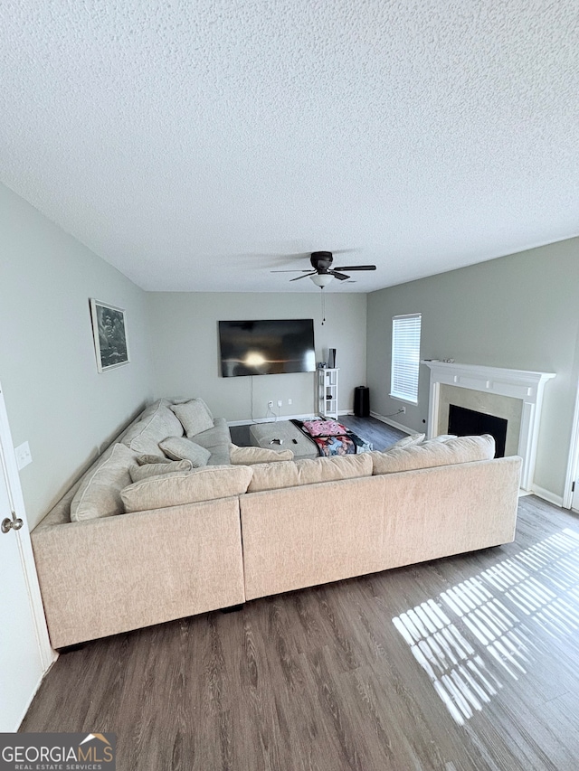 living room with a textured ceiling, wood-type flooring, and ceiling fan