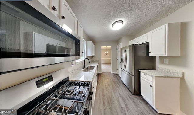 kitchen featuring light hardwood / wood-style flooring, white cabinetry, stainless steel appliances, and sink